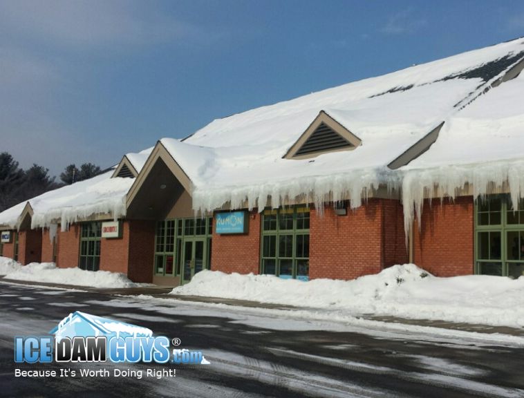 Ice Dam Guys help office buildings with ice dam removals. This photo shows a professional office building with ice dams hanging over the gutters.