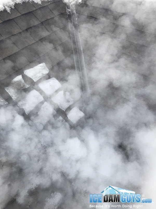 Steaming ice dam in roof valley